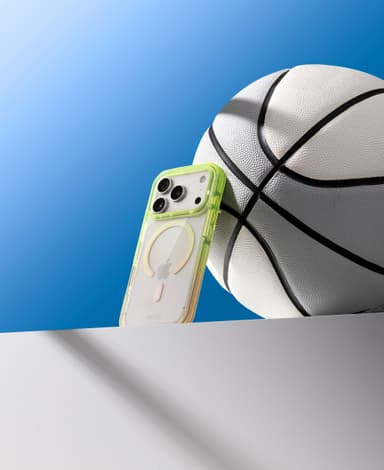 Green CLICK Clear Ombre case propped on a ledge against a basketball, blue gradient sky behind