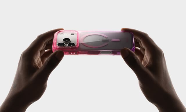 Two hands holding a CLICK Clear Ombre case with a pink-to-purple gradient edge, triple-camera cutout and MagSafe ring in frame