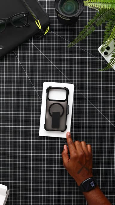 The white inner tray on a black mat, holding the black CLICK Latch Holster case seated in its belt-clip holster