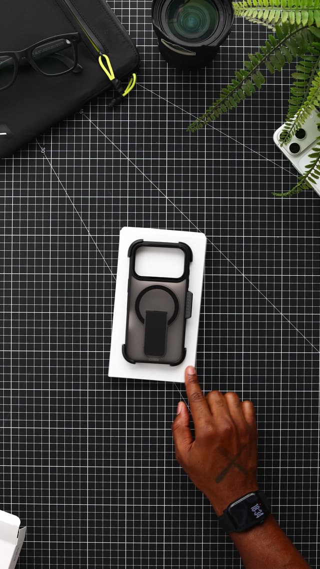The white inner tray on a black mat, holding the black CLICK Latch Holster case seated in its belt-clip holster