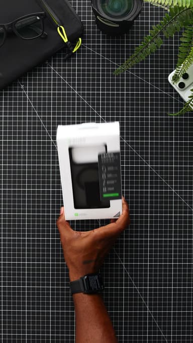 A hand holding the white CLICK retail box for the Latch Holster, the black case visible through the front window